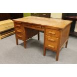 A twentieth century oak desk fitted with six drawers and two slides