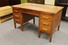 A twentieth century oak desk fitted with six drawers and two slides