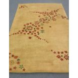 A hand-knotted rug of floral design on gold ground,