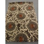 A hand-knotted rug of floral design on brown ground,