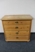 An antique pine four drawer chest with brass drop handles