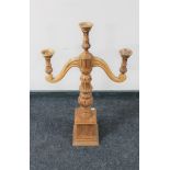 A carved wooden three way table candelabrum