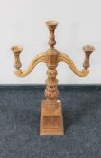 A carved wooden three way table candelabrum