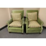 A pair of early 20th century armchairs upholstered in a green fabric with striped cushions