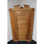 An antique pine corner cupboard