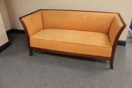 An early twentieth century mahogany framed settee upholstered in peach fabric