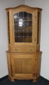 A blond oak leaded glass door corner display cabinet