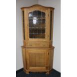 A blond oak leaded glass door corner display cabinet