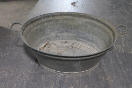 An oval galvanised twin handled wash tub