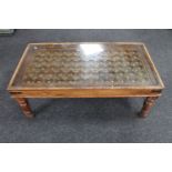 An Eastern glass topped coffee table with metal mounts