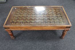 An Eastern glass topped coffee table with metal mounts