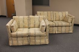 A pair of two seater settees upholstered in floral cream fabric
