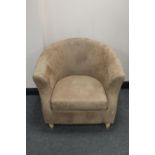 A tub chair upholstered in beige fabric