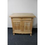 A 20th century blond oak double door sideboard fitted a drawer