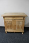 A 20th century blond oak double door sideboard fitted a drawer