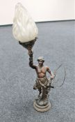 A late 19th century spelter figural table lamp modelled as a blacksmith holding torch aloft