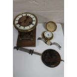 An antique brass and enamelled clock movement with pendulum together with a cased travel clock and
