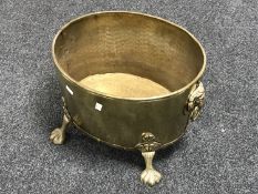 A Victorian brass coal bucket with lion mask handles on raised paw feet