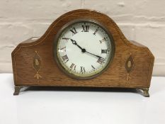 A late 19th century inlaid mahogany mantel clock on brass feet