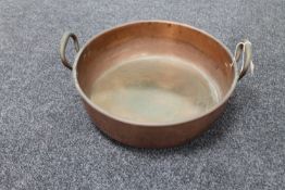An antique copper twin handled cooking pot