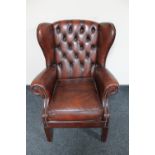 A late 20th century buttoned leather wingback armchair