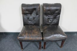 A pair of antique dining chairs in buttoned leather upholstery