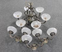 An ornate metal six way light fitting with glass shades together with three double wall lights (one