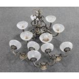 An ornate metal six way light fitting with glass shades together with three double wall lights (one