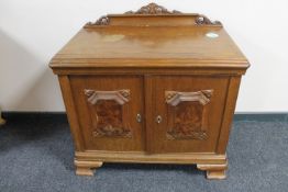 A 20th century continental oak double door cabinet with walnut panelled doors