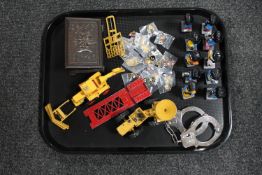 A tray of Robertson's golly figures and pin badges, die cast Matchbox bulldozer,