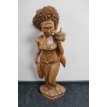 A carved hardwood eastern figure of a lady carrying a pot