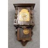 An antique oak cased wall clock with brass dial,