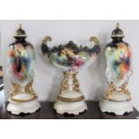 A three piece Victorian pottery vase garniture with bird decoration on stands