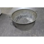 An circular galvanised twin handled wash tub