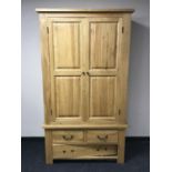 A contemporary oak double door wardrobe fitted three drawers beneath