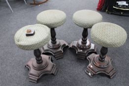 A set of four circular twist column bar stools on wooden bases