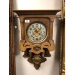 An Edwardian oak wall clock with pendulum