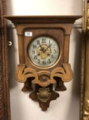 An Edwardian oak wall clock with pendulum