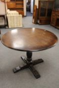 A circular oak pedestal pub style table