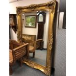 A gilt framed ornate bevelled mirror,