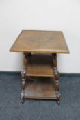 An antique oak three tier occasional table