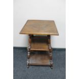 An antique oak three tier occasional table