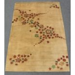 A hand-knotted rug of floral design on gold ground,