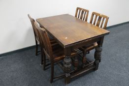 An oak pull out dining table on carved legs together with a set of four oak dining chairs