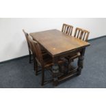 An oak pull out dining table on carved legs together with a set of four oak dining chairs