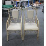 A pair of wrought iron shield back garden armchairs