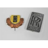 A 20th century Rolls Royce metal emblem Ghost Wraith Dawn badge and a vintage tin Rolls Royce badge