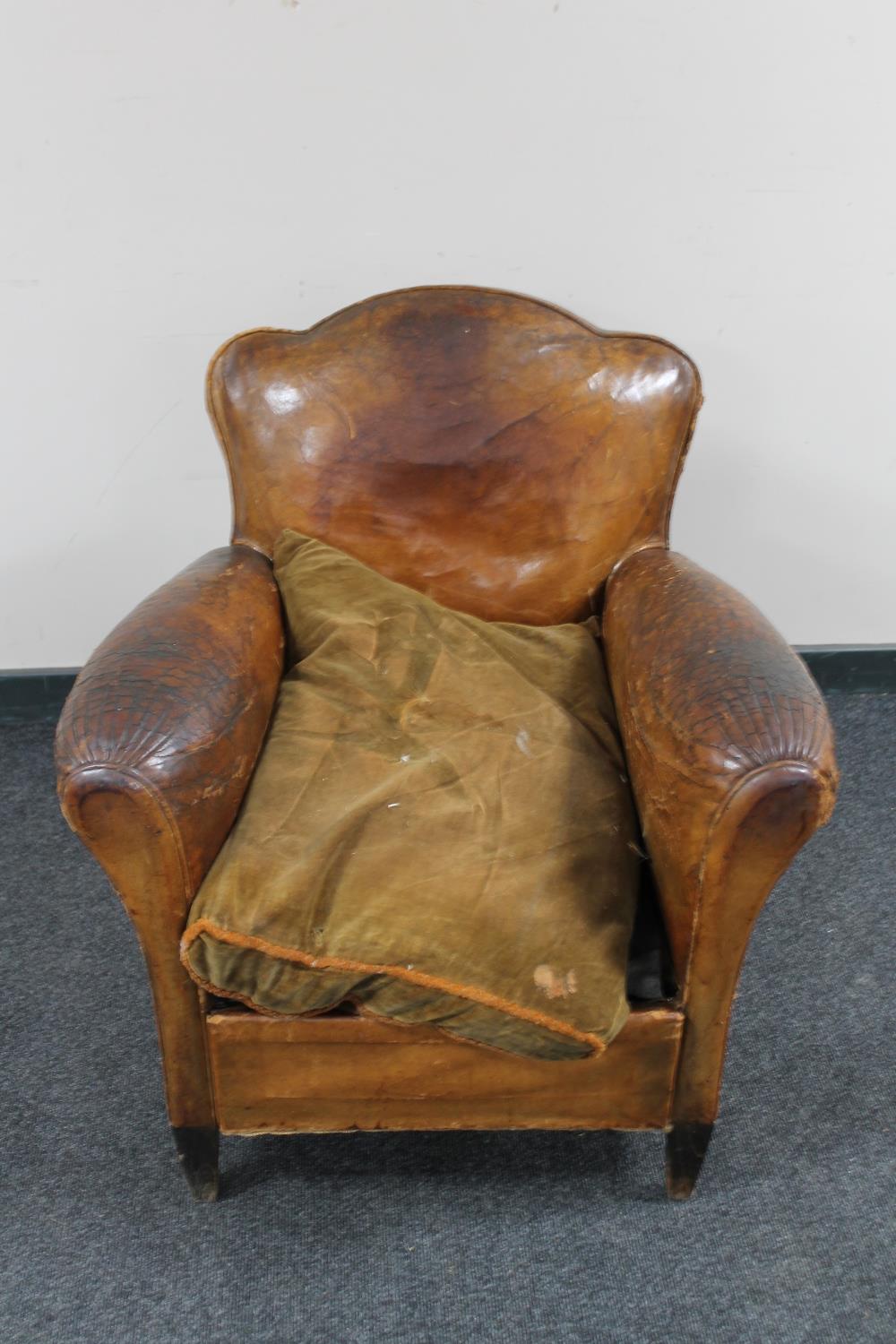 An early 20th century brown leather club armchair