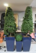 Three artificial trees in planters