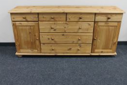A pine dresser fitted cupboards and drawers beneath CONDITION REPORT: 79cm high by
